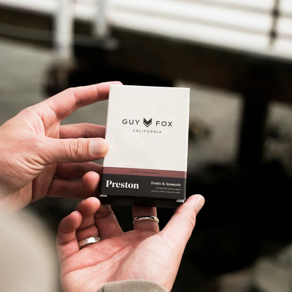 Hands holding "Preston" by Guy Fox California product packaging. Fruity and Aromatic are on the label