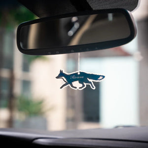 Car air freshener shaped like a fox hanging from a car's rearview mirror.