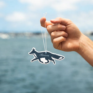 Person holding "Riviera" air freshener by Guy Fox