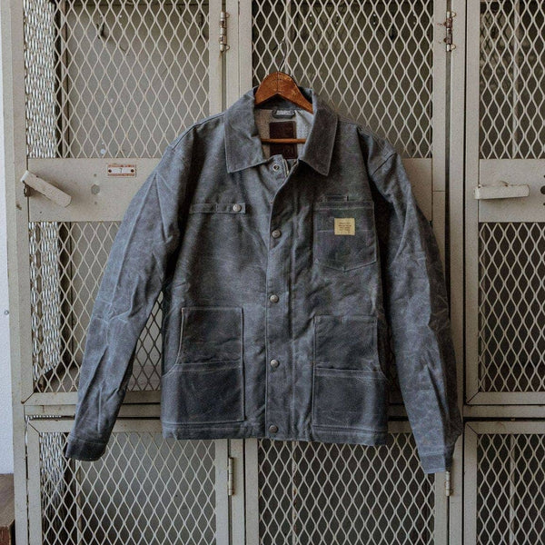 Waxed denim Bradley Mountain jacket hung on gray lockers 